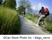 Cyclists pass through a field - ©Can Stock Photo Inc. / diego_cervo