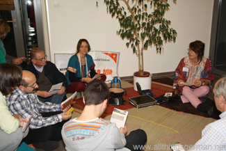 Miriam Schuller (left) and Gabriele Rohde (right) with guests roll-playing a micro-credit meeting under the village tree