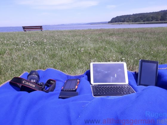 Tablets, camera, solar powerbank and mobile hotspot next to the Jasmunder Bodden in Ralswiek.