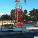 A crane stands in front of the building site