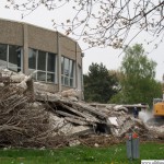 A digger clears part of the debris from the old indoor swimming pool building